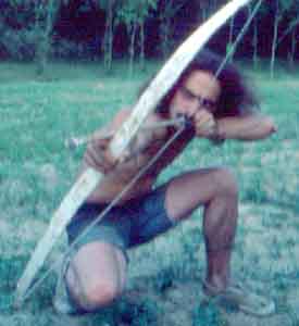 Tom testing a bow and arrow using a n arrowhead found in the fields.
