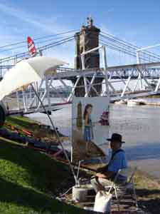 Tom Lohre painting on the Ohio River waterfront a portrat of Helen.
